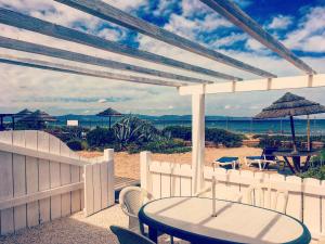 a patio with a table and chairs on the beach at Ô Bord de Mer ! in Hyères +7 photos
