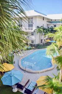 een uitzicht over een zwembad met stoelen en parasols bij Suites at Coral Resorts in Miami