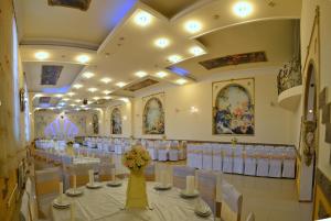 a banquet hall with white tables and white chairs at Oazis in Noratus