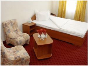 a hotel room with a bed and a table and chairs at Vila Casa Alesiv in Cluj-Napoca +6 photos