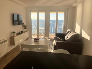 sala de estar con sofá y mesa en Apartamento en primera linia vistas al mar en Platja  d'Aro