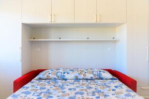a bedroom with a bed with a blue and white bedspread at Appartamento Al Centro Della Vacanza in Portoferraio
