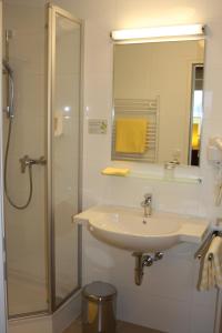 a bathroom with a sink and a shower at Hotel Sonnenhof in Timelkam