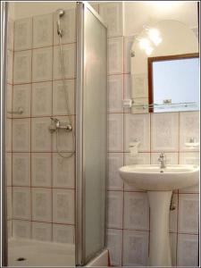 a bathroom with a sink and a shower with a mirror at Vila Casa Alesiv in Cluj-Napoca