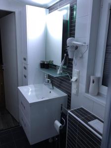 ein weißes Badezimmer mit einem Waschbecken und einem Spiegel in der Unterkunft Chalet SOL Y MAR in Renesse