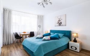 - une chambre avec un lit bleu, une table et des chaises dans l'établissement Apartament Stag Karkonosz - 2 osobne pokoje - by Space Apart, à Jelenia Góra