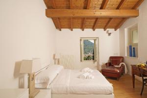 - une chambre avec un lit, un bureau et une chaise dans l'établissement Tenuta La Pineta, à Salò