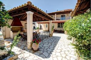 an outdoor patio with a gazebo and a house at Trident Studios and Apartments in Kavos