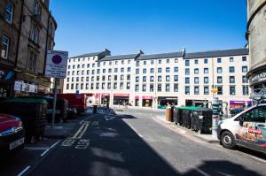 een stadsstraat met een groot wit gebouw bij Montgomery Apartments - Crighton in Edinburgh