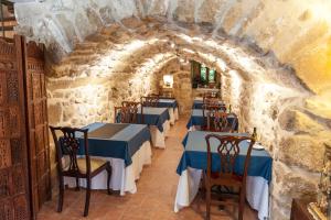 een restaurant met blauwe tafels en stoelen in een stenen muur bij La Casa de Sebastian in Valderrobres
