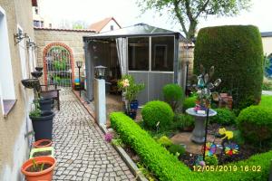 un jardín con invernadero, plantas y árboles en Gästezimmer Zittau - Bed & Breakfast, en Zittau