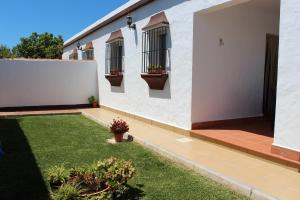 een wit huis met twee ramen en een tuin bij Casa Colada 3 in Conil de la Frontera