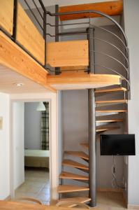 a loft bed with a spiral staircase in a room at Résidence Vacances Fontenelle in Raphèle