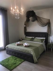 a bedroom with a large bed with a chandelier at B&B Bellavista in Tavullia