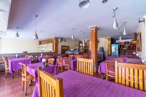 una sala da pranzo con tavoli e sedie viola di Kacu Ubud Inn ad Ubud
