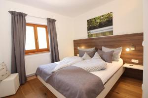 1 dormitorio con 1 cama grande y cabecero de madera en Beim Bicher, en Grabenstätt
