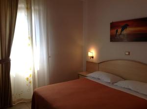 a bedroom with a bed and a picture on the wall at Hotel Corallo in Torre Santa Sabina