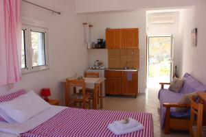 1 dormitorio con 1 cama y cocina con mesa en Aaron Studios Apartments, en Agia Fotia