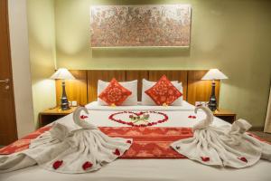 una cama con dos cisnes hechos de toallas en River Sakti Ubud by Prasi, en Ubud