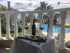 ベレキにあるBelek Golf Village - Villa with shared poolのポーチのテーブルの上に盛り付けられた料理とワイン
