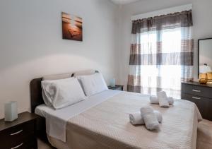 a bedroom with a bed with two towels on it at Andria City Apartment in Zakynthos