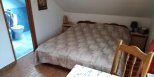 1 dormitorio con cama, mesa y espejo en Dobogókő vendégház, en Dobogoko