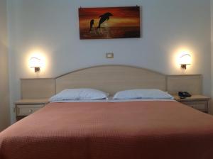 a bedroom with a bed with two people in the water at Hotel Corallo in Torre Santa Sabina