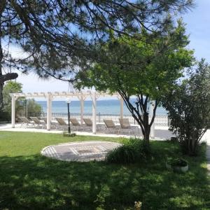 a park with a gazebo and chairs and the ocean at Iris Hotel in Canakkale