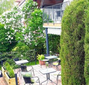 un patio con tavoli e sedie e un balcone. di GÄSTEHAUS LIFESTYLE a Kirrweiler