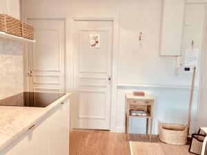 カンヌにあるClassic Appartementのキッチン(白いキャビネット、カウンタートップ付)