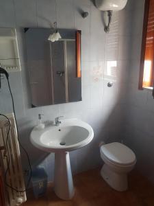ein Badezimmer mit einem weißen Waschbecken und einem WC in der Unterkunft Leopardi in Lequile