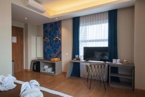 TV a/nebo společenská místnost v ubytování Luminor Hotel Airport Sidoarjo By WH , Best Choice and Strategic Location with a Rooftop area in Town