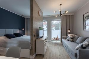 - une chambre et un salon avec un lit et un canapé dans l'établissement Apartament CLIF, à Świnoujście