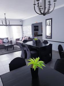 sala de estar con mesa negra y sillas en Hiflyerz Guest House, en Boksburg