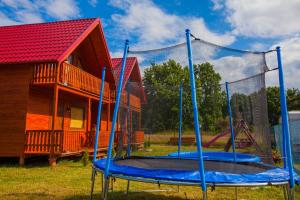 a playground with a house and a trampoline at Domki Zacisze in Ostrowo