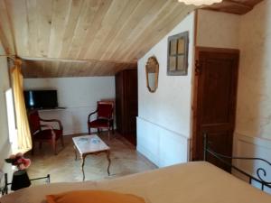 Habitación con cama, mesa y sillas. en La Tour Mandot, en Montluel
