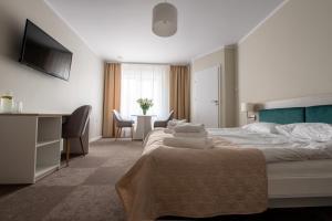 um quarto de hotel com uma cama, uma secretária e uma mesa em Biały Gościniec em Ciechanów