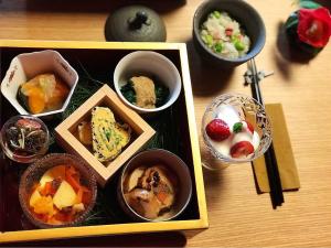 a tray of different types of food in bowls on a table at Atelier Bee's Knees Bed & Breakfast in Ikuma
