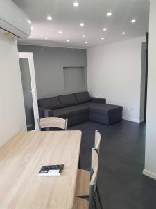 a room with a table and chairs and a couch at Picurka Apartman in Siófok