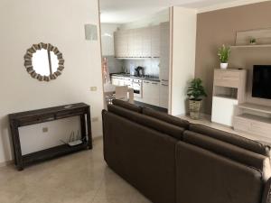 ein Wohnzimmer mit einem Sofa und einer Küche in der Unterkunft Maison Donatello in Valeggio sul Mincio