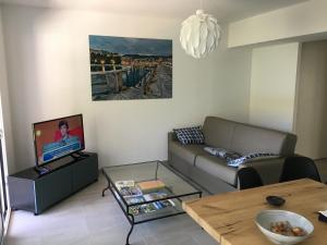 een woonkamer met een bank en een tafel bij Charmant T2 Hauteurs de Bastia in Bastia