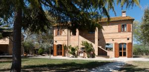 a large brick house with a tree in front of it at ValleChiara B&B in Recanati