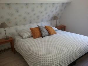 a bedroom with a bed with pillows and two lamps at Au Nid Douillet in Seigy