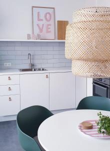een keuken met een witte tafel en groene stoelen bij Appartement Plek in Holten in Holten