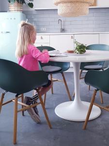 een klein meisje aan een tafel in een keuken bij Appartement Plek in Holten in Holten