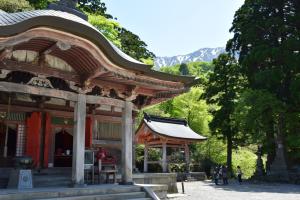 a building with a roof with people standing in front of it at Hotel Daisen Shirogane in Daisen