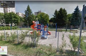 een speeltuin met een glijbaan in een park bij Katica Apartman in Miskolc