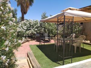 una mesa y sillas bajo una sombrilla en un jardín en Sapir Apartment, en Sappir