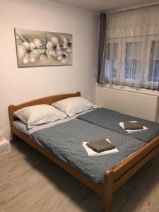 a bedroom with a bed with two books on it at Apartmans and rooms ''Slavica'' in Novalja