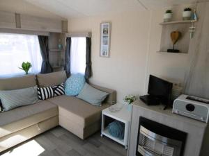 a living room with a couch and a fireplace at Chalet Joleen IJmuiden aan zee, vlakbij het strand in IJmuiden